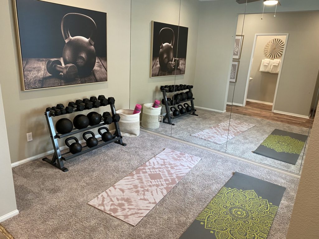 Rack of weights and yoga mats inside Verbena model home