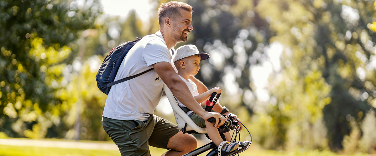 man riding bike with infant son